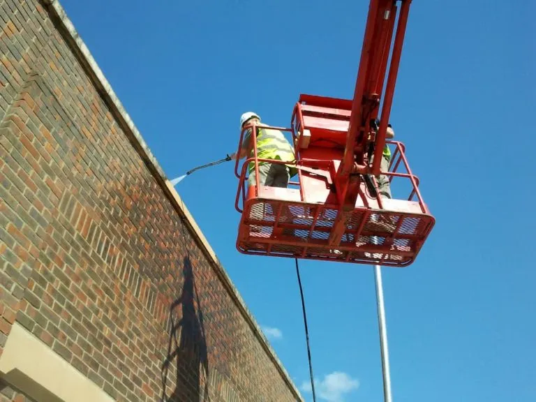 Cherry picker being used to pressure wash building